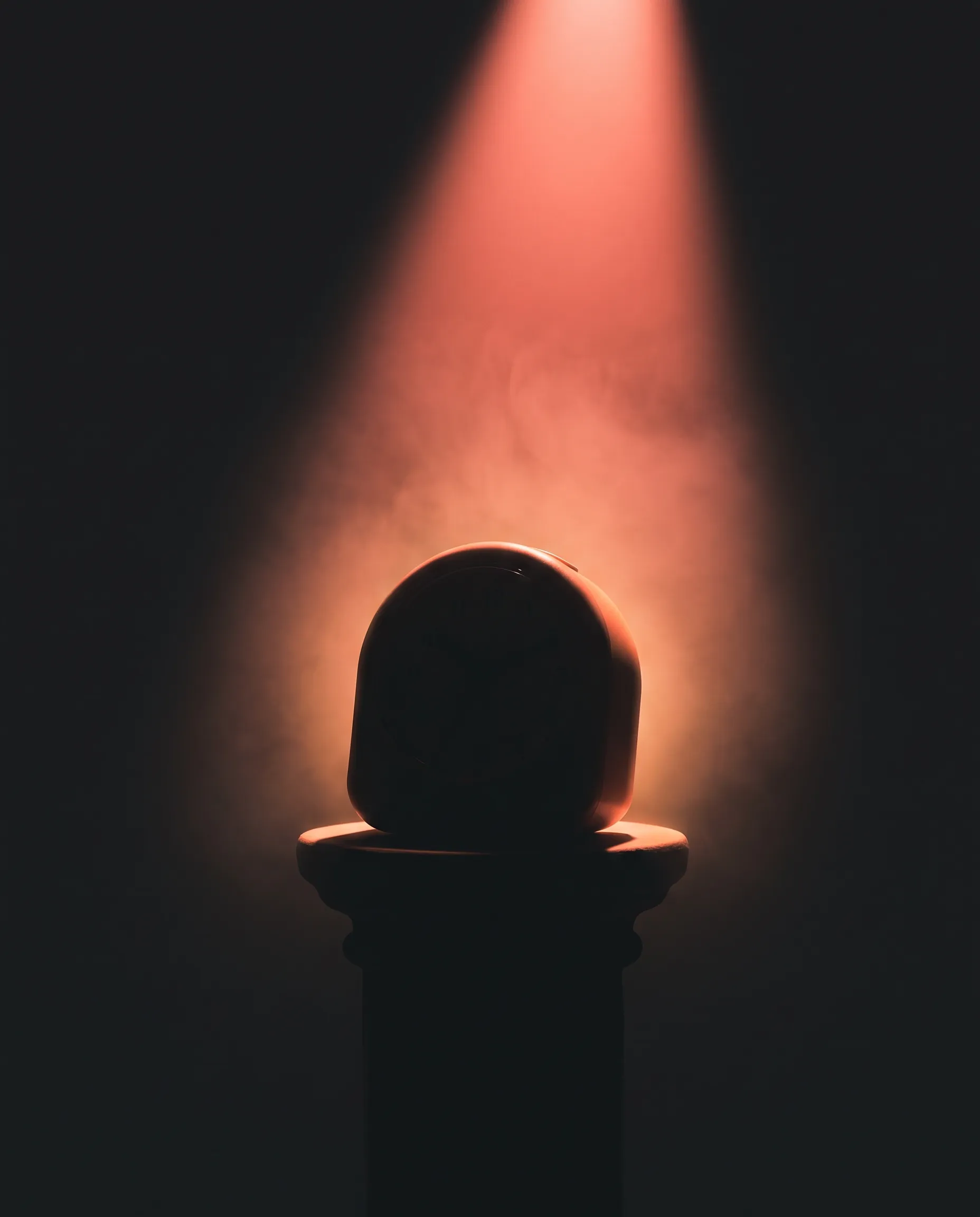 Our next product hidden in shadow under a warm spotlight, still under wraps
